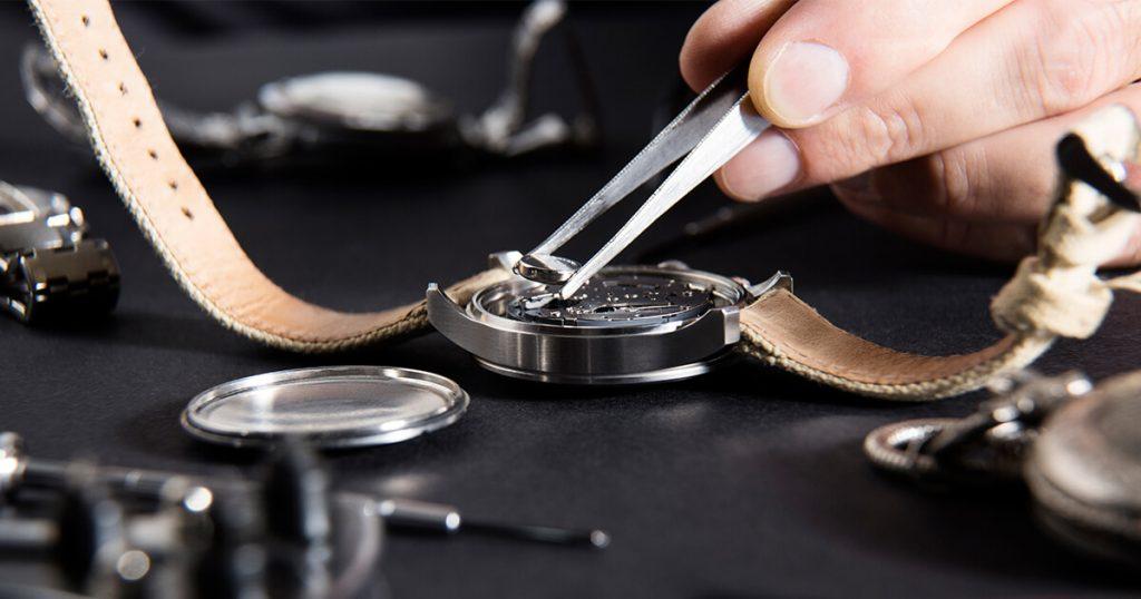 detail of the work of a watchmaker who replaces a battery
