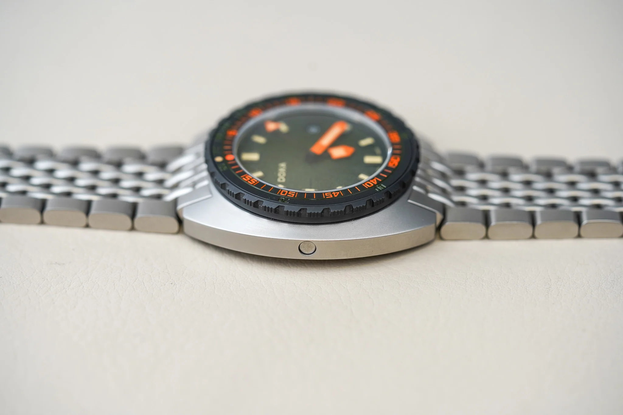 DSC02869 Ceas de scufundări Belmont Watches X Doxa Sub 300 Beta “Frogger” cu carcasă din metal, bezel negru cu marcaje portocalii și brățară metalică, vedere laterală.