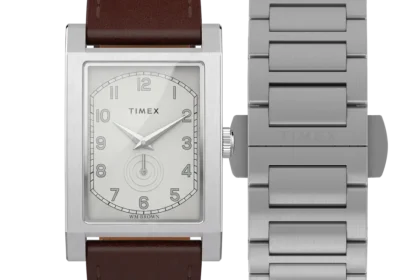 Ceas dreptunghiular Timex cu cadran alb și curea din piele maro, alături de o brățară metalică argintie suplimentară.