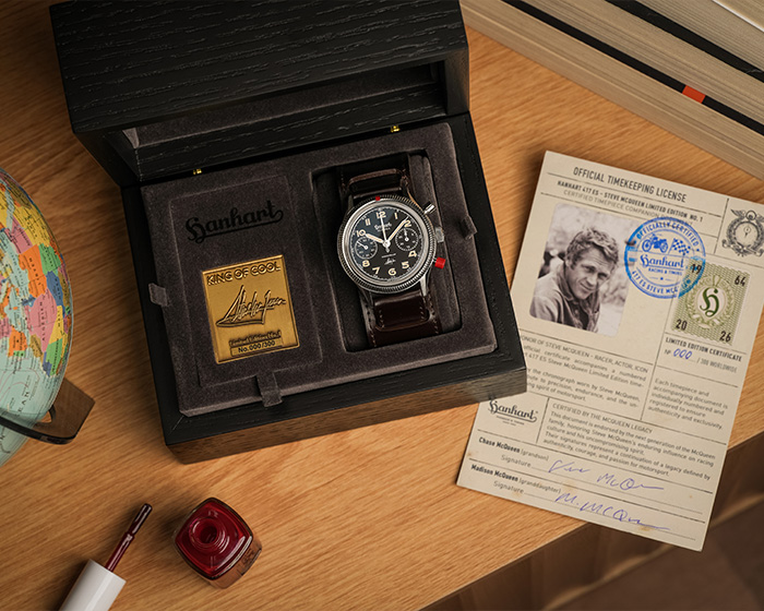 hanhart Steve McQueen website Ceas Hanhart Steve McQueen Limited Edition No.1 în cutie de prezentare neagră, lângă certificat oficial și o mică glob de birou.